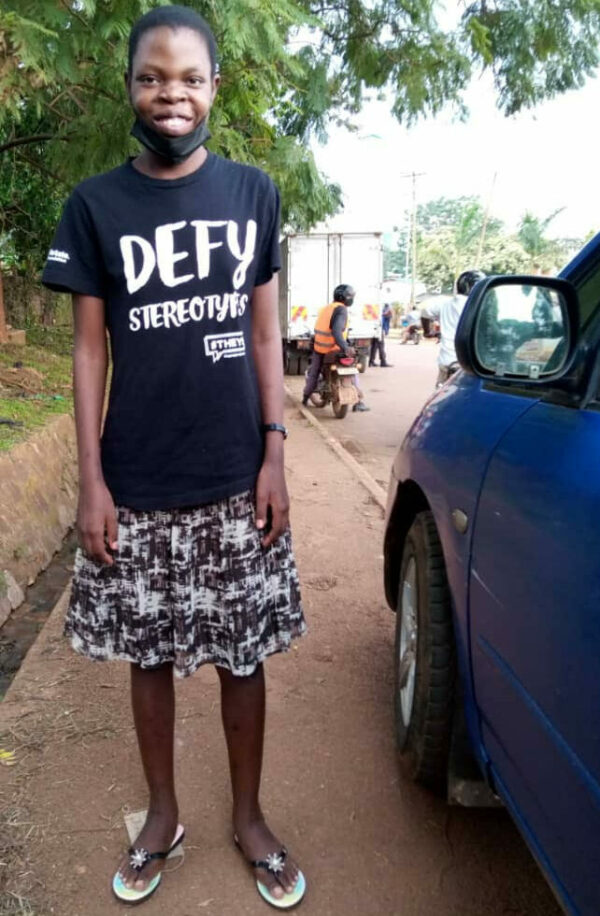Ugandan girl standing on the sidewalk in a black T-shirt and skirt