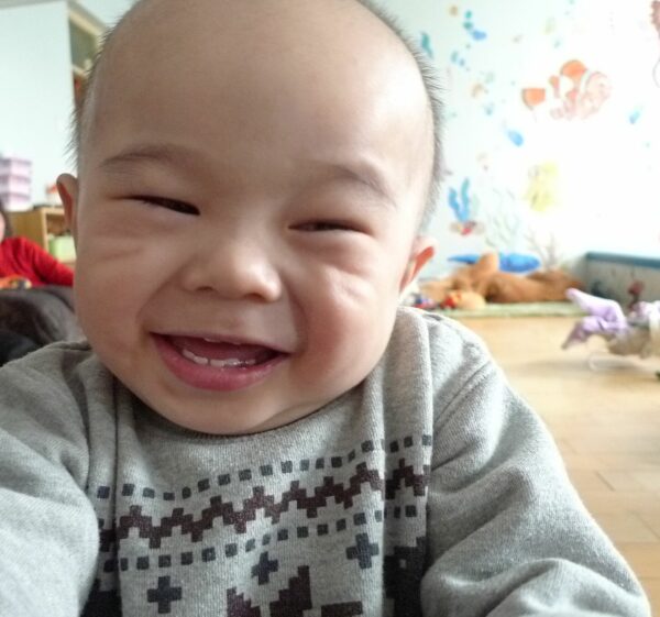 Baby boy grinning big in a healing home