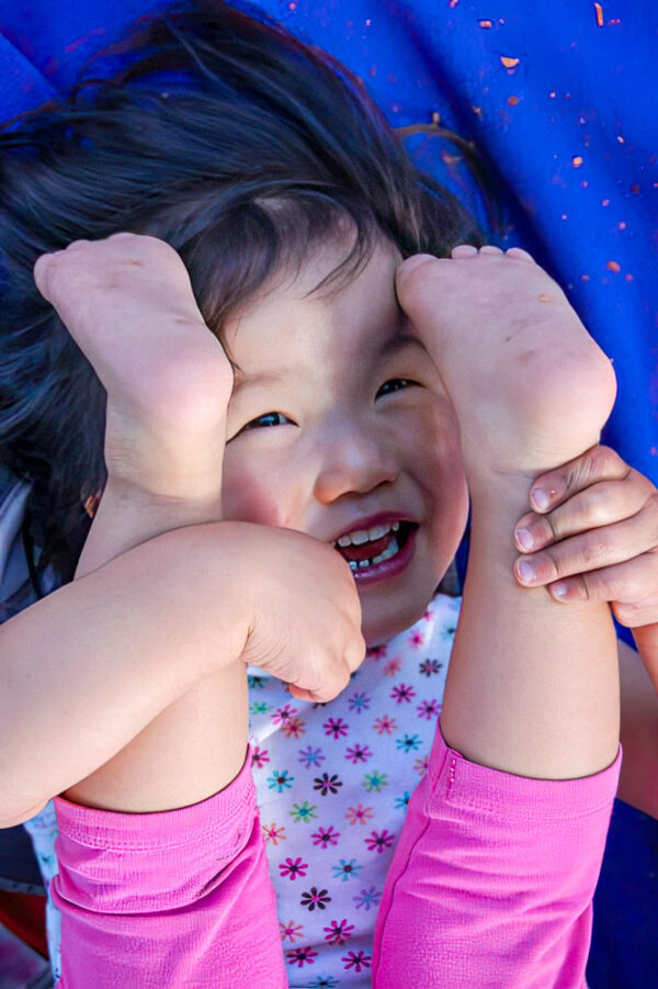Little girl with feet in the air laughing