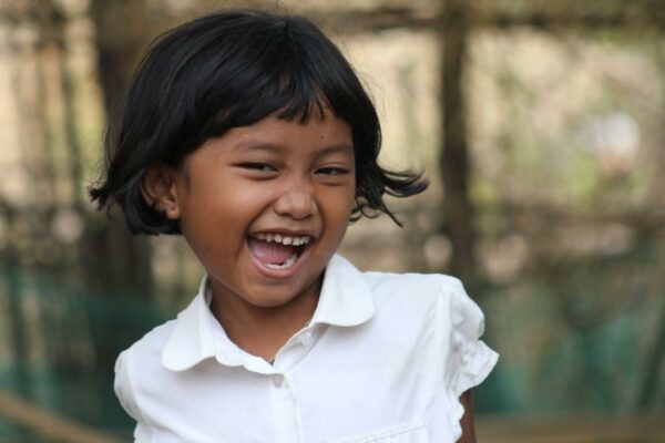 Cambodian girl laughing wearing a white collared shirt