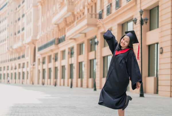 Young woman in a cap and gown celebrating her graduation in Cambodia