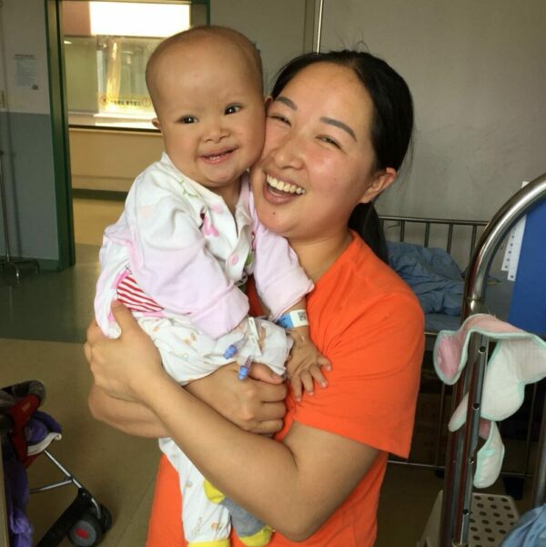 Smiling baby boy and woman upon discharge from the hospital