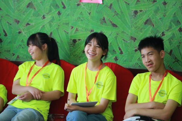 Three teens in bright yellow T-shirts attend Life Skills Camp for Orphaned Teens