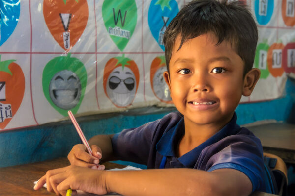 Little boy writing in school in Cambodia