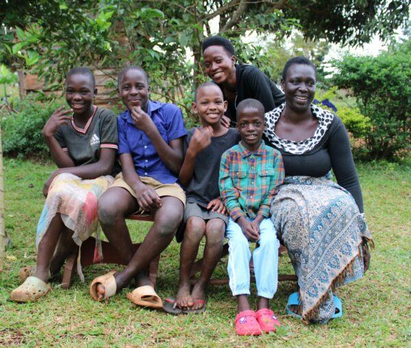 A happy foster family sits together in Uganda