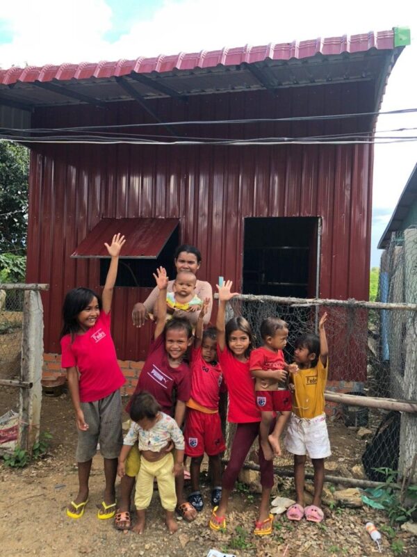 A mom and 8 children wave in front of their new house 20 Years of Hope Jennifer