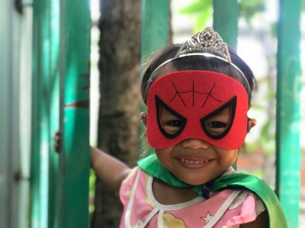Little girl wearing a tiara and a Spiderman mask