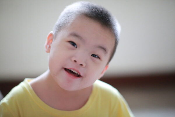 Little boy with Down syndrome in a yellow t-shirt