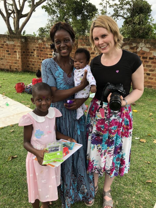 Ugandan mom, her baby, and young daughter with an LWB team member
