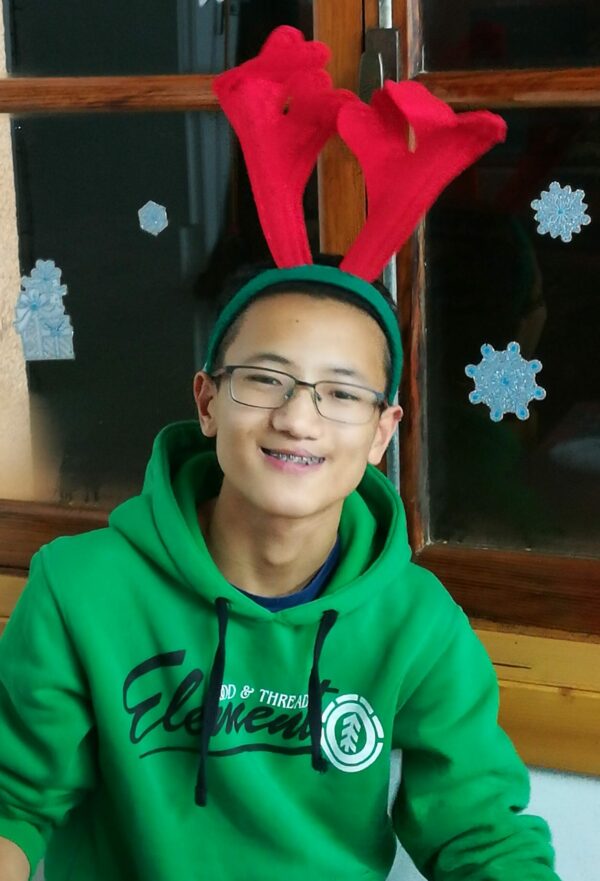 Teenage boy in a green hoodie wearing red antlers
