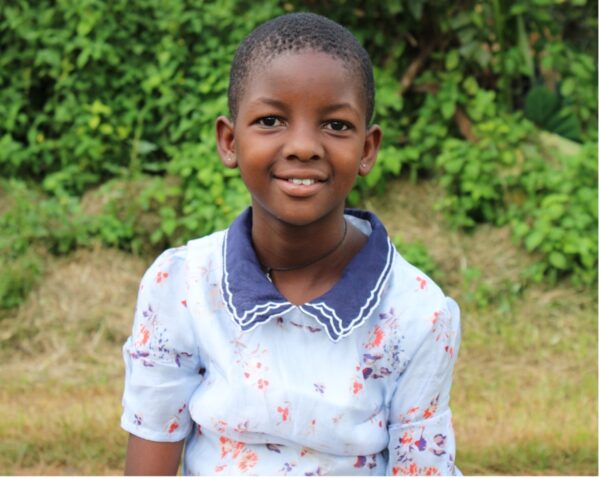 Young girl in Uganda in a blue dress 20 Years of Hope