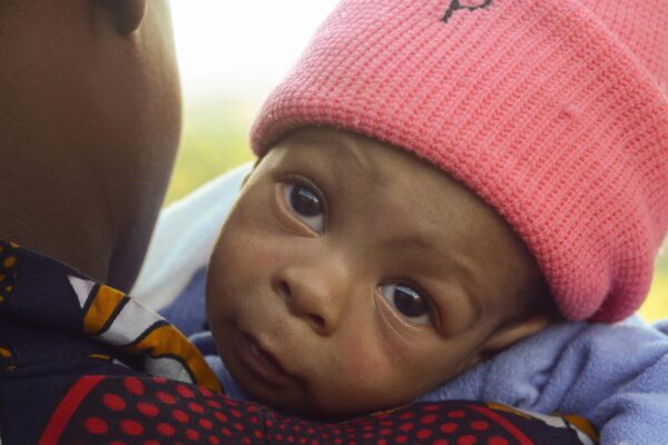 Tiny baby in need of cardiac care in Uganda wearing a pink cap