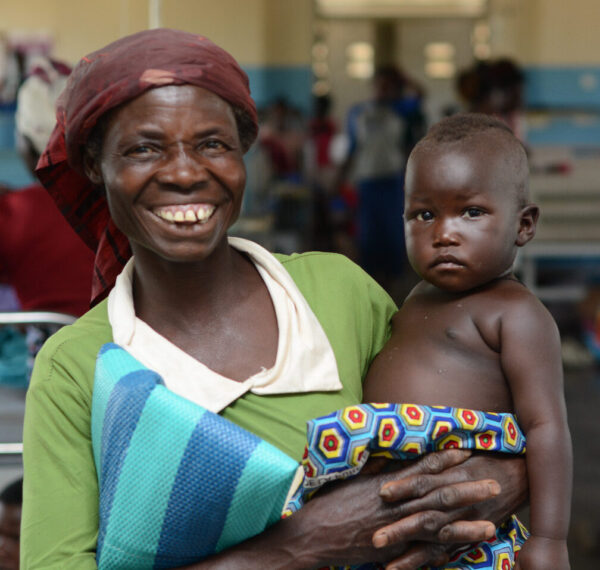 Smiling mother holds her baby at a Ugandan hospital
