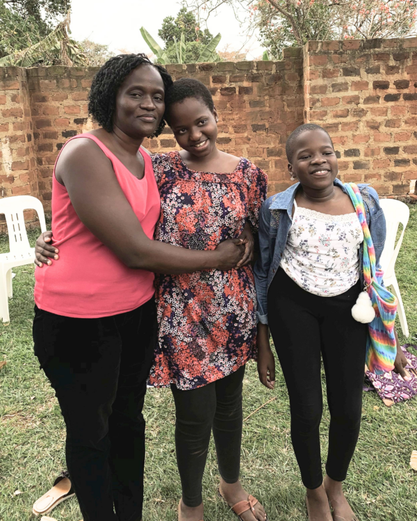 Young girl with scoliosis with her sister and mom standing outside