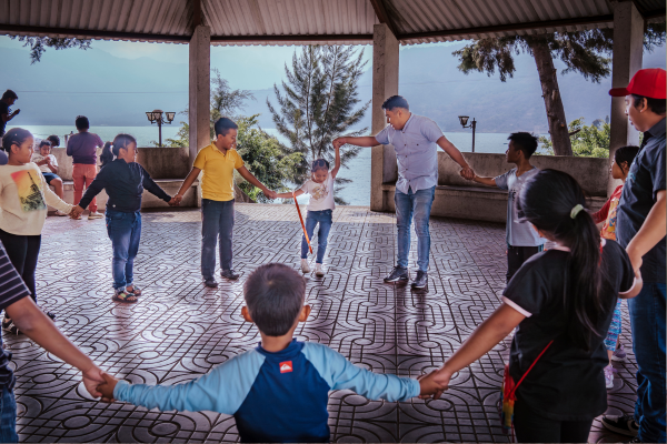 Circle of children and adults in a gazebo