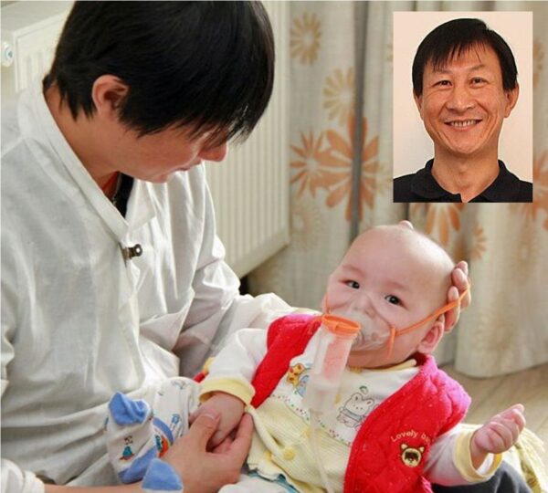 Man holding a baby on oxygen