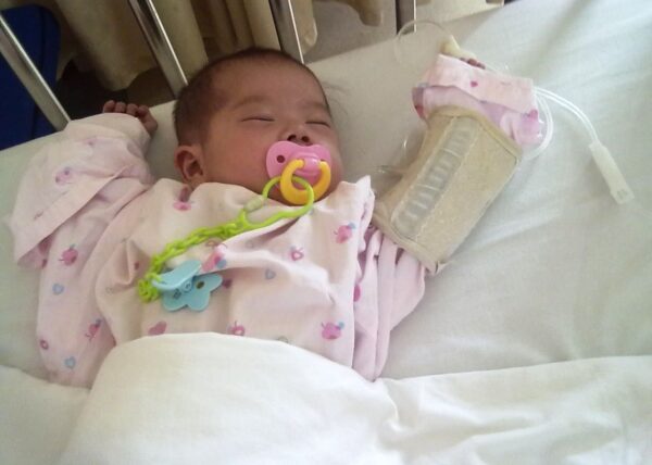 Baby with pacifier sleeps in hospital