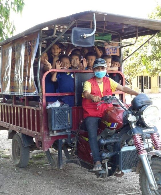 Cambodian tuk-tuk filled with children going to school