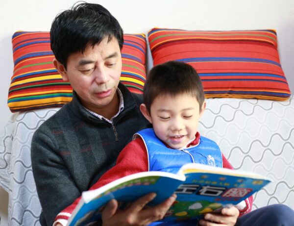 Man and boy reading a book together