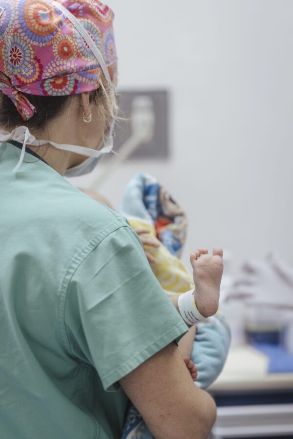 Nurse holding a baby during cleft surgery