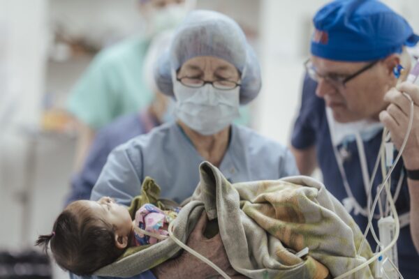 Doctors examine a baby during cleft repair surgery