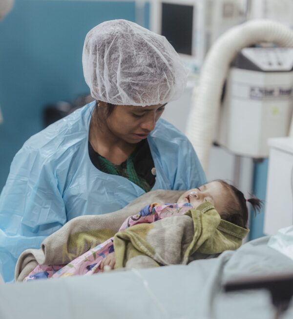 Mom tenderly holds her baby after cleft repair surgery