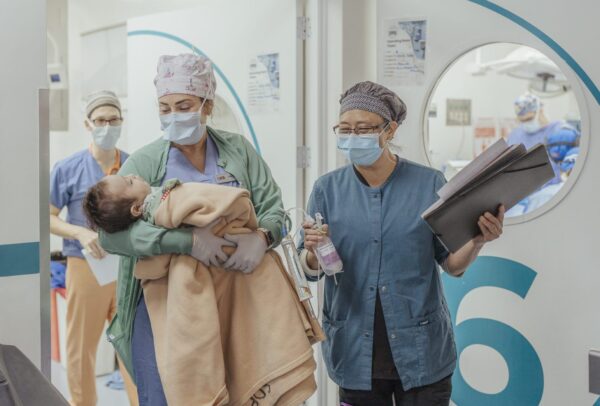 Nurses carry a baby in hospital