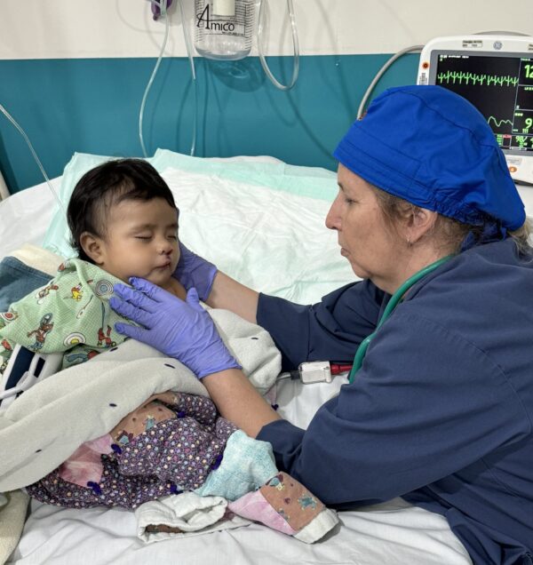 Nurse examining baby after cleft surgery
