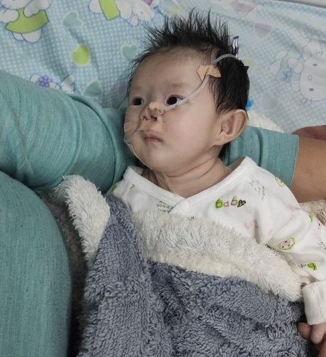 Baby in hospital cradled in her mother's arm