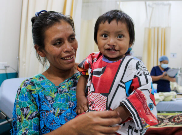 Boy with cleft lip in hospital being held by his mom
