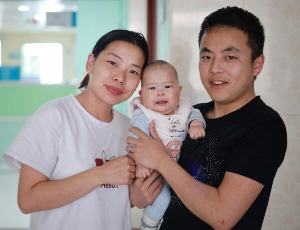 Mom and dad hold their baby in hospital after surgery through LWB's Unity Initiative