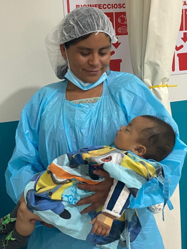 Mom holds her son after cleft lip surgery