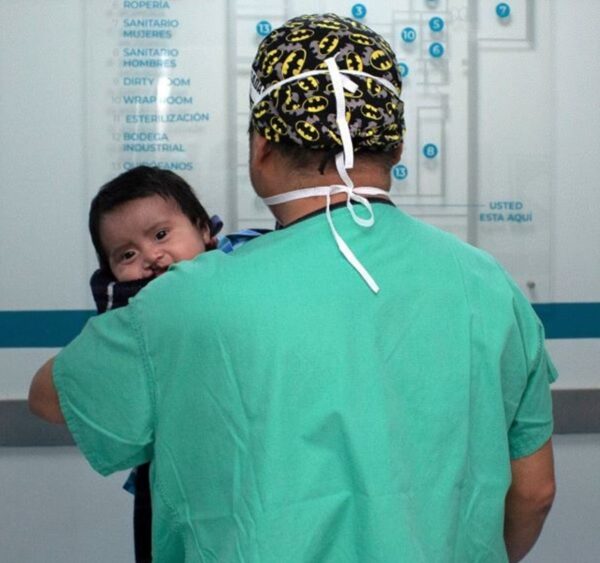 Baby with cleft lip being carried to the operating room